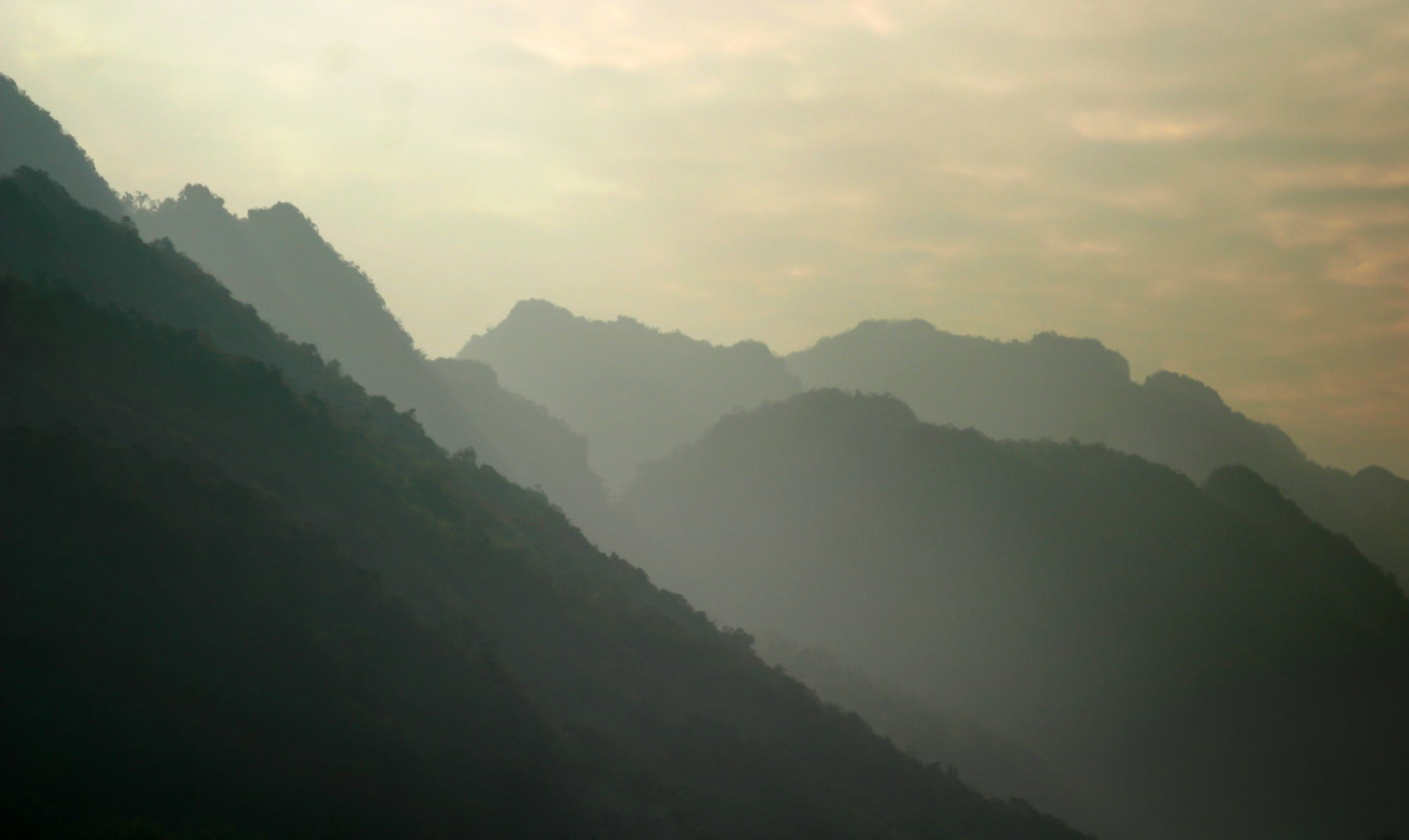 Layered mountain ridges under an overcast sky.